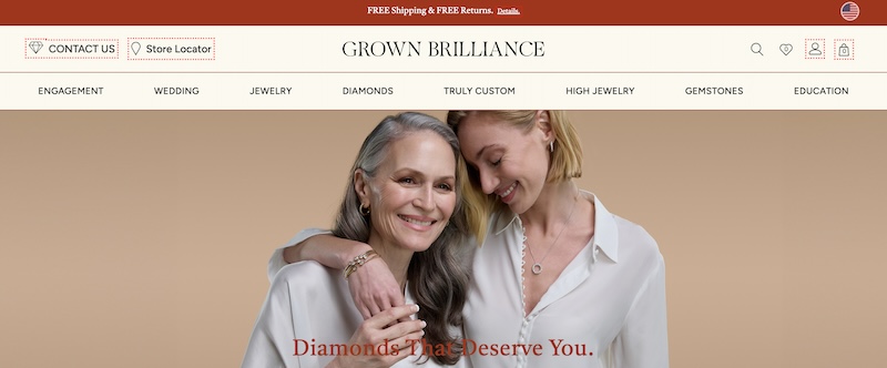Screenshot of the Grown Brilliance homepage featuring two smiling women embracing, one older with grey hair and one younger with blonde hair, both wearing white tops. The older woman is showing off a diamond ring. The website's navigation includes options like ENGAGEMENT, WEDDING, JEWELRY, DIAMONDS, TRULY CUSTOM, HIGH JEWELRY, GEMSTONES, and EDUCATION. There's a prominent tagline that reads 'Diamonds That Deserve You.' The website offers free shipping and free returns, with links for 'CONTACT US' and a 'Store Locator.